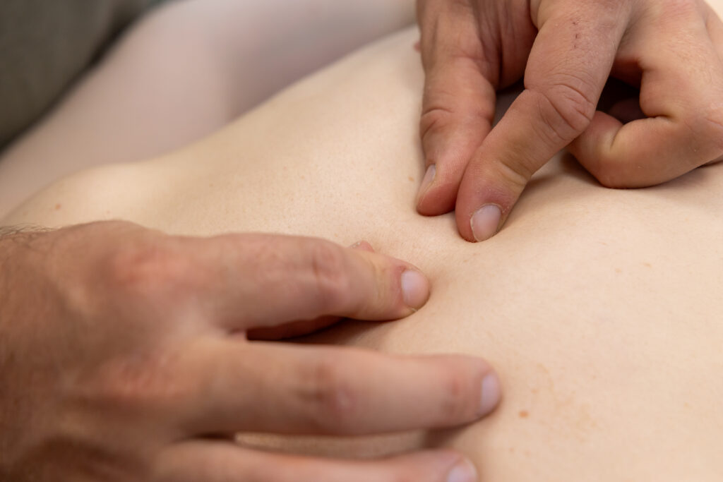 Nahaufname bei der Testung des Rückens einer Patientin in der Osteopathie Praxis Burmester im Dreiländereck Schweiz Frankreich und Deutschland